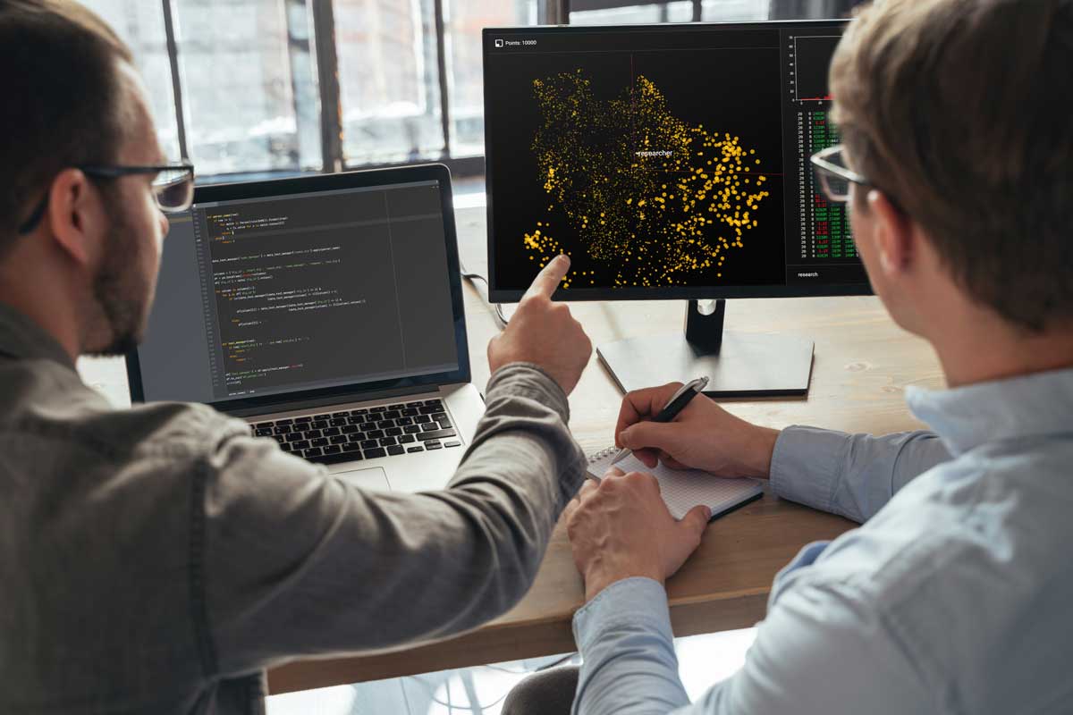 Closeup of two men data science specialists working at office together, analyzing big data on screen. Coders working on new project